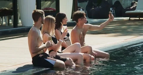 Group of friends having fun at pool. Taking selfie on smartphone sitting Stock Footage 158610735