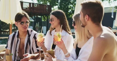 Group of friends having fun at pool. People cheers drinking summer cocktails at Video stock 158727043