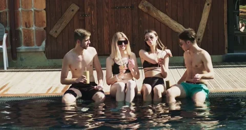 Group of friends having fun at pool. People cheers drinking summer cocktails at Video stock 158728426