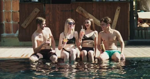 Group of friends having fun at pool. People cheers drinking summer cocktails at Video stock 158830784