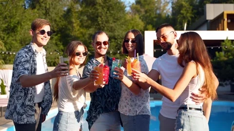 Group of friends having fun at poolside summer party clinking glasses with Stock Footage 132325131