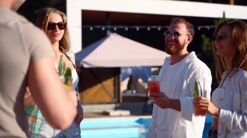 Group of friends having fun at poolside summer party clinking glasses with Video stock 132325517