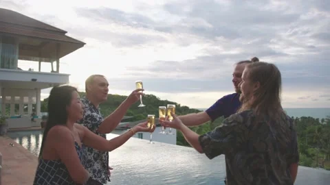 Group of friends having fun at poolside party clinking glasses with white wine Stock Footage 235280364