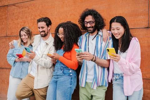 Group of friends having fun using a cellphone to browse on internet. Young adult Stock Photos