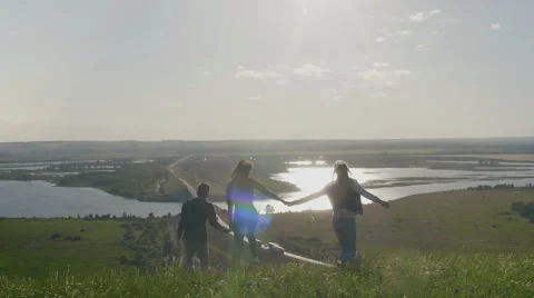 Group Of Friends Hold Hands on a high hill overlooking the highway at summer Stock Footage 65039333