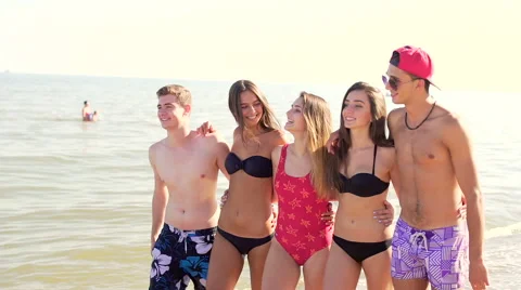 Group of friends hugging while walking at beach and starts to run  Stock Footage 67349337