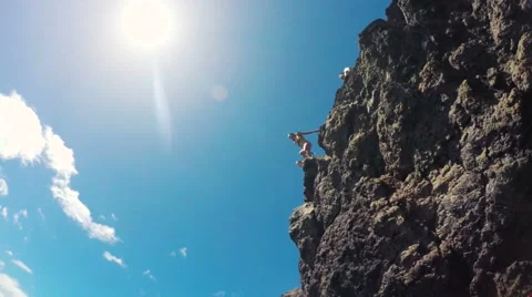 Group of friends jumping from cliff into the ocean in Hawaii. Water Shot Unde Stock Footage 55545671