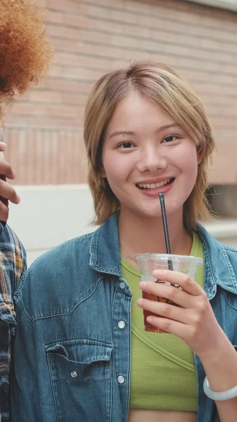 Group of friends looking at camera smiling and drinking takeaway drinks Stock Footage 252031460