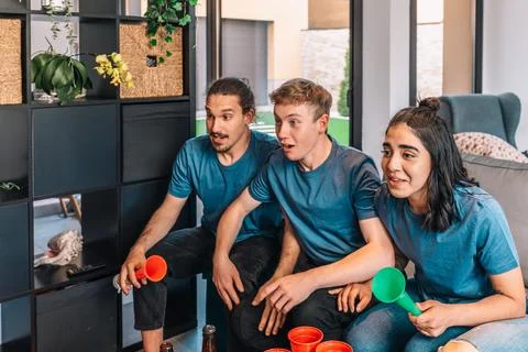 Group of friends looking forward to the possible victory of their sports team Stock Photos