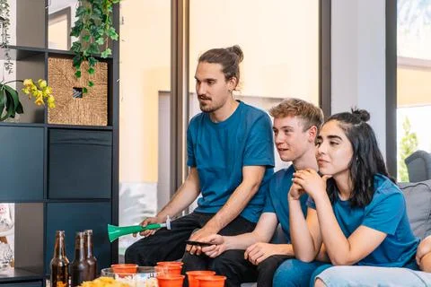 Group of friends looking forward to the possible victory of their sports team Stock Photos