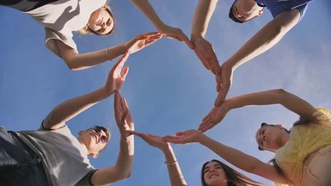 A group of friends makes a circle from the palms of their hands. Stock Footage 116985614
