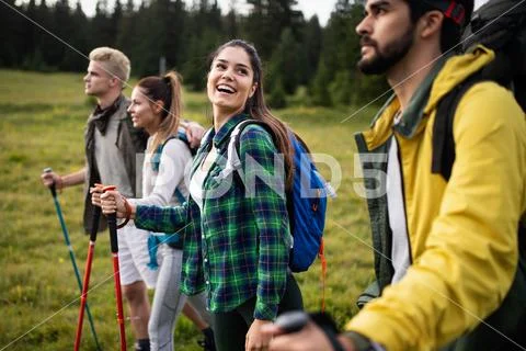 Group of friends on a mountain. Men and women climbing rocks. Stock Photos
