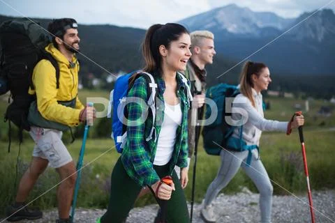 Group of friends on a mountain. Men and women climbing rocks. Stock Photos