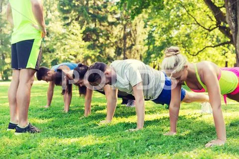 Group of friends or sportsmen exercising outdoors Stock Photos
