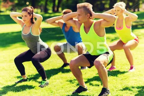 Group of friends or sportsmen exercising outdoors Stock Photos