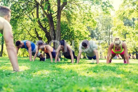 Group of friends or sportsmen exercising outdoors Stock Photos