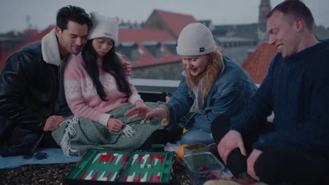 Group Of Friends Play A Competitive Game Of Backgammon On A Rooftop Stockbeeldmateriaal 282916675