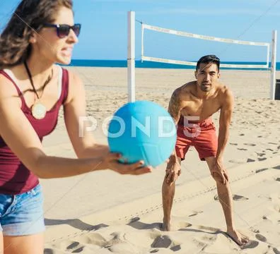 Group Of Friends Playing Volleyball On Beach
