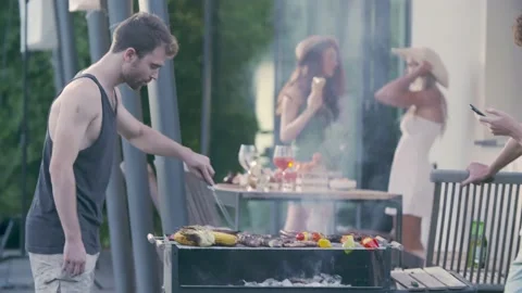 Group of friends preparing meat bbq. Double couple of friends talking, drinking 動画素材 156228205