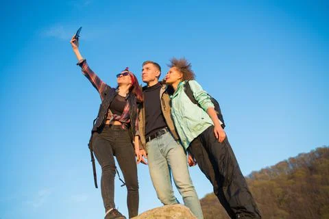 Group of friends resting on mountain while hiking. Hikers relaxing and taking 스톡 사진
