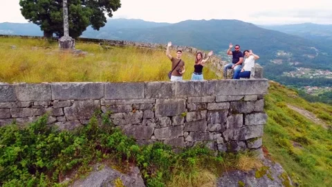 Group of friends saying goodbye to the camera at the top of a mountain with a Stock Footage 134498066
