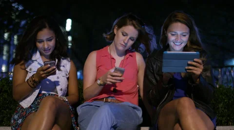 Group of friends sharing information on their digital devices in the city Stock Footage