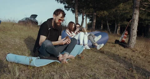 A group of friends sit down in the park, relax and talk. Stock Footage 139284395
