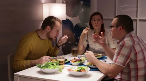 Group of friends sitting around table at home Stock Footage 58100451