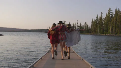 Group of Friends Skip Down a Boat Dock Together Video stock 208710122