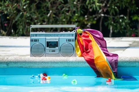 Group of friends sunbathing in the pool with old record player. lgtbi movemen Stock Photos