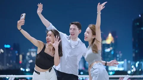 Group of friends taking selfies together with night city urban view background Stock Footage 276798876