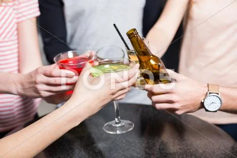 Group Of Friends Toasting With Beer And Cocktails