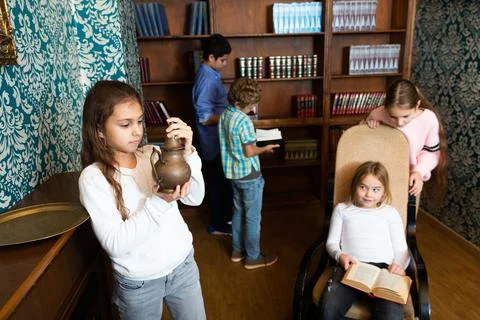 Group of friends trying to find solution of quest in escape room with antique Fotos de archivo