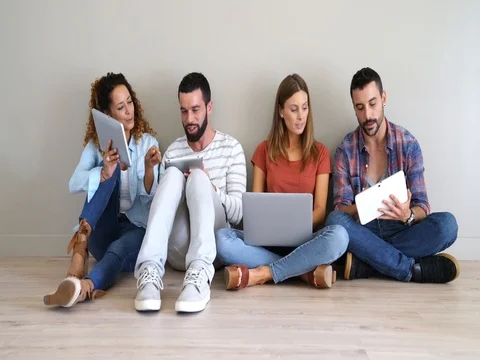 Group of friends using laptop and tablet, sitted on floor Stock Footage 80138393