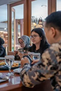Group of friends using smartphones while dining at a restaurant Stock Photos