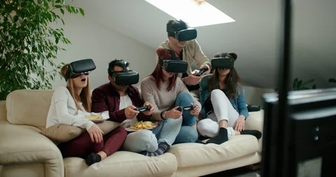 Group of friends using virtual reality simulator glasses in living room Stock Footage 117182814
