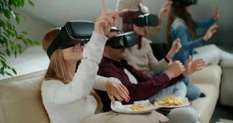 Group of friends using virtual reality simulator glasses in living room Stock Footage 117182847