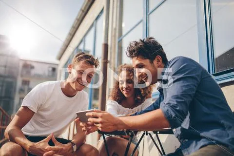 Group of friends watching video on smartphone Stock Photos