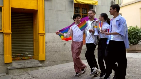 Group of friends waving rainbow flags during pride parade Stock Footage 318828289