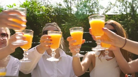 Group of friends in white having breakfast and toasting with yellow orange juice Stock-Footage 114317746