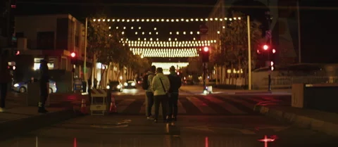 Group Gathering Under String Lights on Urban Street, 1.5x Anamorphic Stockbeeldmateriaal 299169685