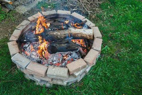 Group gathers around fire pit in backyard during evening time for warmth an.. Фото
