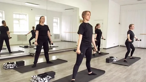 A group of girls doing a lunge exercise in a fitness class. Stock Footage 239691165