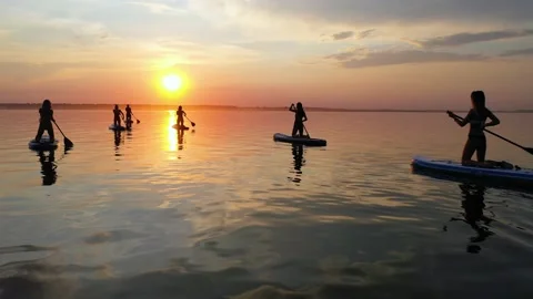 Group of girls simultaneously rowing the oars on the SAP Board Stock Footage 135260867