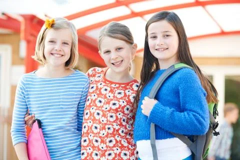 Group Of Girls Standing Outside School With Book Bags Stock Photos