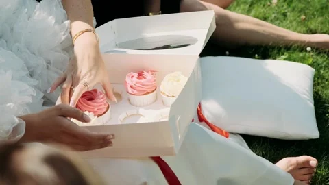A group of girls take cupcakes from a box Stock Footage 284154853