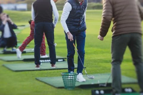 Group of golfers practicing and training golf swing on driving range practice Foto stock