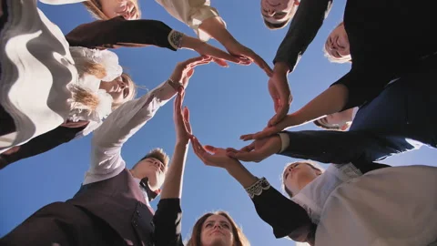 A group of graduate students make a circle from the palms of their hands. Stock Footage 117035756