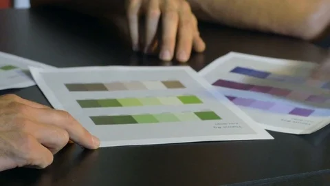 Group of graphic designers discussing about colored pallet guides. Video stock 80472484
