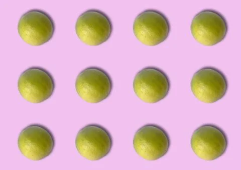 Group of green lemons on violet background. Stock Photos
